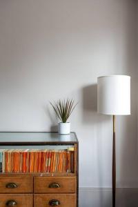 a lamp and a dresser with a potted plant on it at Trinity Square Georgian Townhouse in Margate