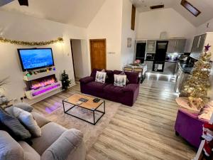 a living room with two couches and a tv at Hayloft at Bonnyside House in Bonnybridge