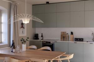 a kitchen with a wooden table with chairs and a kitchen with white cabinets at SeaSide LOFTS im Herzen von Westerland in Westerland (Sylt)