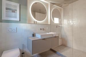 a white bathroom with a sink and a shower at SeaSide LOFTS im Herzen von Westerland in Westerland (Sylt)
