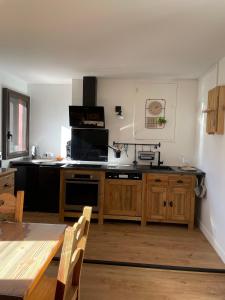 uma cozinha com uma mesa e uma bancada em CASTEL ISARD - Le Refuge em Porté-Puymorens