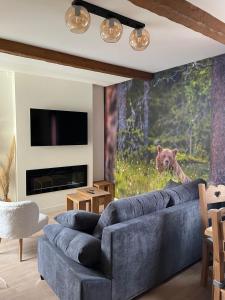 a living room with a blue couch and a bear mural at CASTEL ISARD - Le Refuge in Porté-Puymorens