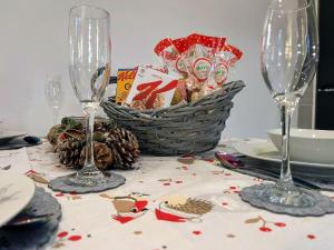 a table with two wine glasses and a basket of food at Hayloft at Bonnyside House in Bonnybridge