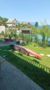 una tabla de surf sobre la hierba en un patio en Lejla apartmani - Jablaničko jezero, en Konjic