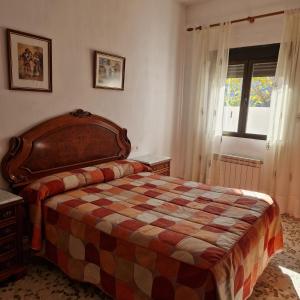 Un dormitorio con una cama grande y una ventana. en Apartamentos Haza La Moraleda, en Güéjar-Sierra 170 fotos más