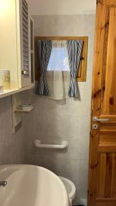 a bathroom with a tub and a toilet and a window at La betulla in Perrero