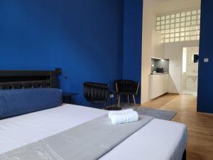 1 dormitorio con paredes azules y 1 cama con 2 sillas en SPA SPA Apartments Vyšehrad, en Praga