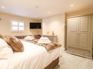 a bedroom with two beds and a flat screen tv at Dovedale in Ashbourne