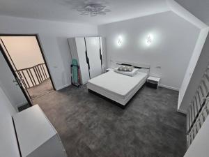Habitación blanca con cama y escalera en Comfy & Cozy Apartament 2, en Rădăuţi