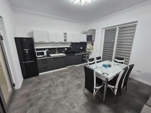 a kitchen with a table and chairs in a room at Comfy & Cozy Apartament 2 in Rădăuţi +5 photos