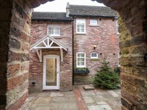 a red brick house with a white door at Monsal Dale in Ashbourne