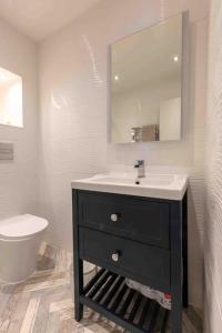 a bathroom with a sink and a toilet and a mirror at The Terrace At Westbrook - Pet friendly in Margate