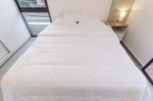 two beds in a small room with a window at Distinguished And Elegant Apartment 2 Bedroom in Asuncion +40 photos