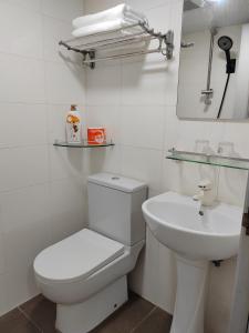 a white bathroom with a toilet and a sink at Le Cong Fraternal Guest House in Hong Kong