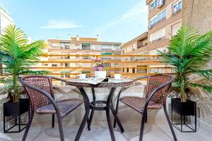 een tafel en stoelen op een balkon met een gebouw bij Genteel Home San José in Granada