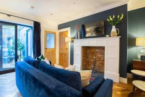 a living room with a blue couch and a fireplace at The Coves in Margate