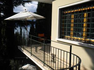 a balcony with an umbrella and a table at Appartamenti Le Dimore 2 in Torri del Benaco