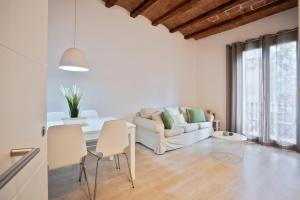 a living room with a white couch and a table at BcnStop Sant Pau Suites in Barcelona