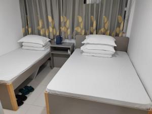 two beds in a small room with at Le Cong Fraternal Guest House in Hong Kong