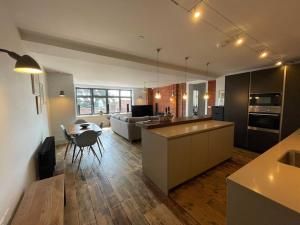 a kitchen and living room with a table and a couch at Luxury 1 Bedroom Apartment Lymington, New Forest in Lymington