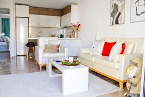 a living room with a white couch and a table at Ermis Mini Suite # 1 in Chalkida