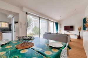 un salon avec une table et un canapé dans l'établissement Entre coeur de ville et plage, maison pour 6, à Saint-Gilles-Croix-de-Vie