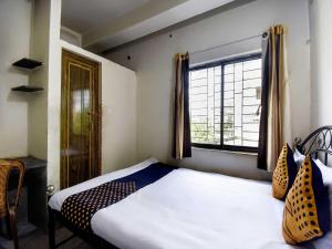 - une petite chambre avec un lit et une fenêtre dans l'établissement OYO Flagship H B Guest House, à Ballygunge