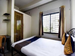 - une petite chambre avec un lit et une fenêtre dans l'établissement OYO Flagship H B Guest House, à Ballygunge