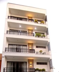 a white apartment building with balconies and potted plants at Bliss Apartments Colombo in Colombo