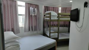 a room with two bunk beds and a television at Le Cong Fraternal Guest House in Hong Kong