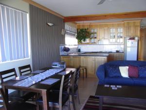 a kitchen and dining room with a table and a blue couch at Lavender House Bed & Breakfast in The Entrance