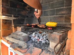 a person is cooking meat on a grill at Ericeira Destination in Ericeira