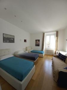 1 dormitorio con 3 camas y sofá en Urbanflat Roma en Roma