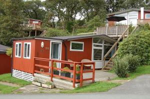 una casetta rossa con portico e ponte di Bryniau Gwyrdd Chalet 11 Happy Valley a Tywyn