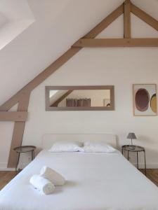 - une chambre avec un lit blanc et 2 serviettes dans l'établissement Charmante petite maison en plein centre ville, à Caen