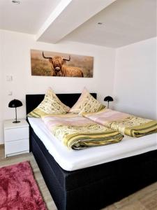 uma cama com uma foto de um touro na parede em charmantes Landhaus "Wildrose", kurz vor Halle, 4 Schlafzimmer em Petersberg