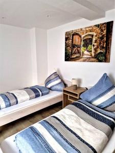 um quarto com três camas e um quadro na parede em charmantes Landhaus "Wildrose", kurz vor Halle, 4 Schlafzimmer em Petersberg