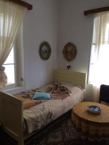 een slaapkamer met een bed en een tafel en ramen bij Lanina kuca 