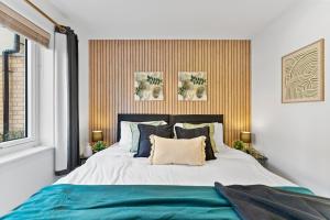 - une chambre avec un grand lit et des oreillers bleus dans l'établissement Beautiful 2 Bed Apartment in Warwick - Parking, à Leek Wootton