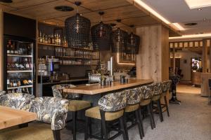 a bar with chairs and a table in a restaurant at Hotel Seespitz in Ischgl