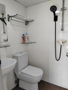 a white bathroom with a toilet and a sink at Le Cong Fraternal Guest House in Hong Kong