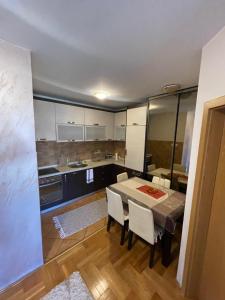 a kitchen and dining room with a table and chairs at One bedroom apartment in urban area in Podgorica