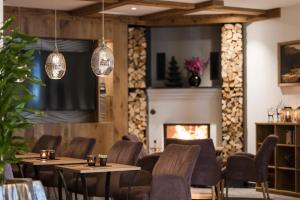 a restaurant with tables and chairs and a fireplace at Hotel Seespitz in Ischgl
