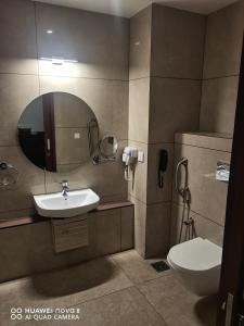 uma casa de banho com um lavatório, um WC e um espelho. em HOTEL EMERALD PALACE em Kottiyam