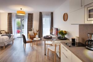 a living room with a kitchen and a living room with a bed at DOMITYS L'ALLIACEE in Achères