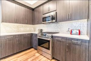 a kitchen with stainless steel appliances and wooden cabinets at Comfortable & Spacious 2BDR - 2BTH for 4 Guests in Hollywood in Los Angeles