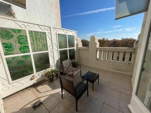un patio con 2 sillas y una mesa en el balcón en Apartamento con terraza y vistas AlcaláRetiro en Madrid