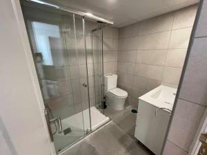 y baño con ducha, aseo y lavamanos. en Apartamento con terraza y vistas AlcaláRetiro en Madrid