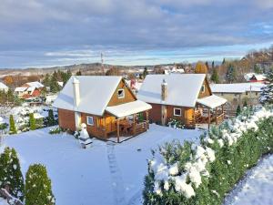 a cabin in the snow with snow covered roofs at Domek BB in Podgórzyn