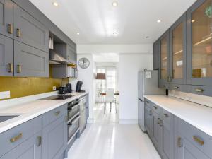 a kitchen with gray cabinets and a white floor at The Courtyard in Pulborough